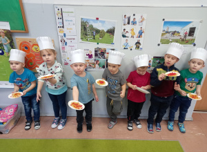 Dzieci prezentują wykonaną pracę w postaci talerza z makaronem